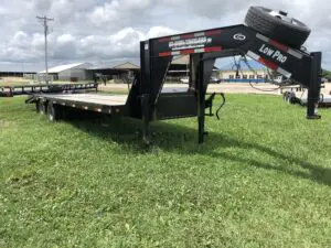 A large trailer is parked in the grass.