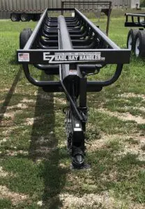 A trailer that has been bent over and is parked on the grass.