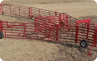 A red fence in the middle of an empty field.